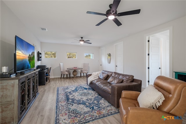 living room featuring ceiling fan and light hardwood / wood-style flooring