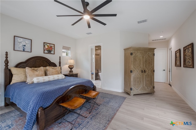 bedroom featuring light hardwood / wood-style floors, ensuite bath, and ceiling fan