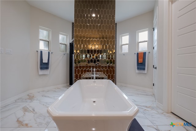 bathroom with a tub and a healthy amount of sunlight