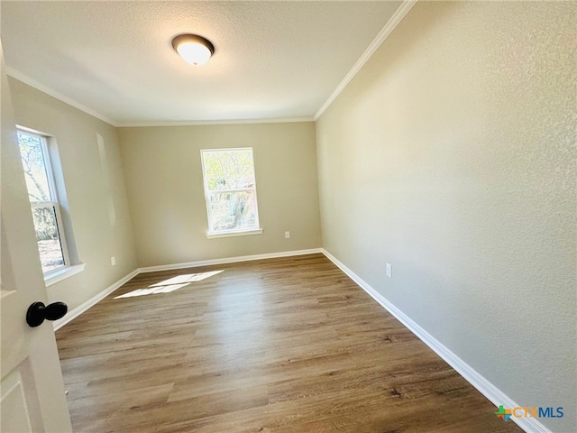 empty room with light hardwood / wood-style floors and ornamental molding