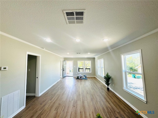 unfurnished living room featuring hardwood / wood-style flooring, crown molding, and a wealth of natural light