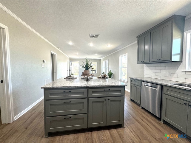 kitchen featuring stainless steel dishwasher, a healthy amount of sunlight, and dark hardwood / wood-style flooring