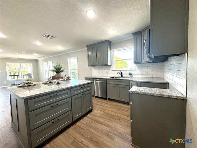 kitchen with a center island, light hardwood / wood-style flooring, gray cabinetry, crown molding, and appliances with stainless steel finishes