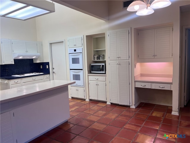 kitchen featuring white cabinetry, tasteful backsplash, and white appliances