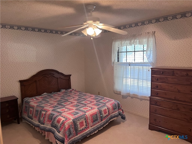 bedroom featuring ceiling fan, a textured ceiling, and light carpet