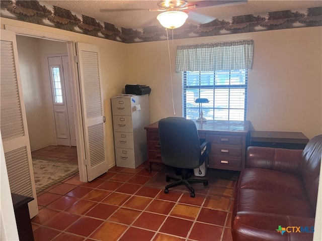 office space with a textured ceiling, tile patterned flooring, and ceiling fan