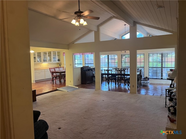 living room with beamed ceiling, carpet, ceiling fan, and a healthy amount of sunlight