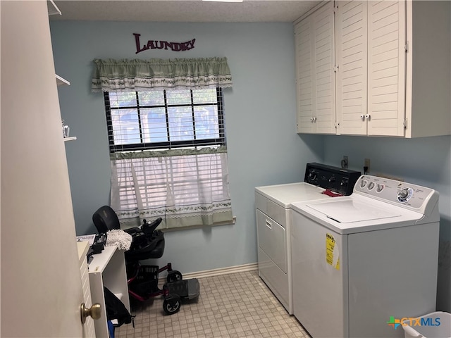 washroom with a textured ceiling, cabinets, and independent washer and dryer