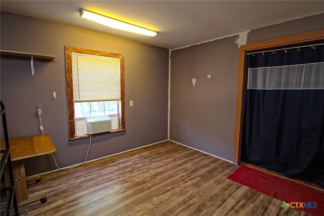 unfurnished room with cooling unit and wood-type flooring