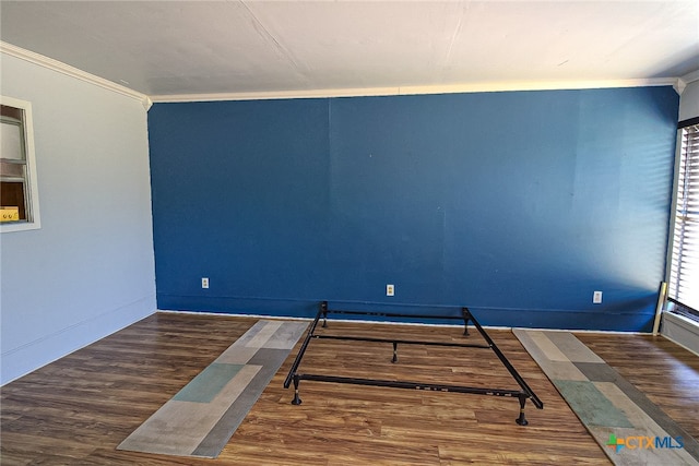 spare room with dark hardwood / wood-style flooring and crown molding