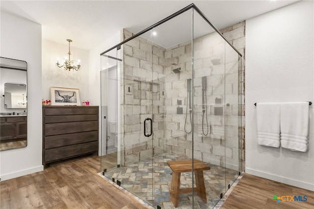 29720 Twin Creeks Dr, Bulverde, TX 78163 - bathroom featuring baseboards, wood finished floors, a shower stall, vanity, and a chandelier