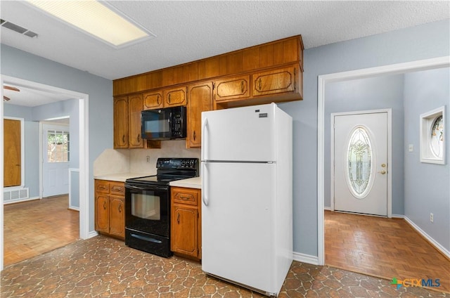 1606 Cedar Oaks Ln, Harker Heights, TX 76548 - kitchen with black appliances, light countertops, brown cabinetry, and a textured ceiling
