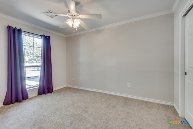 empty room featuring ceiling fan, crown molding, and light carpet