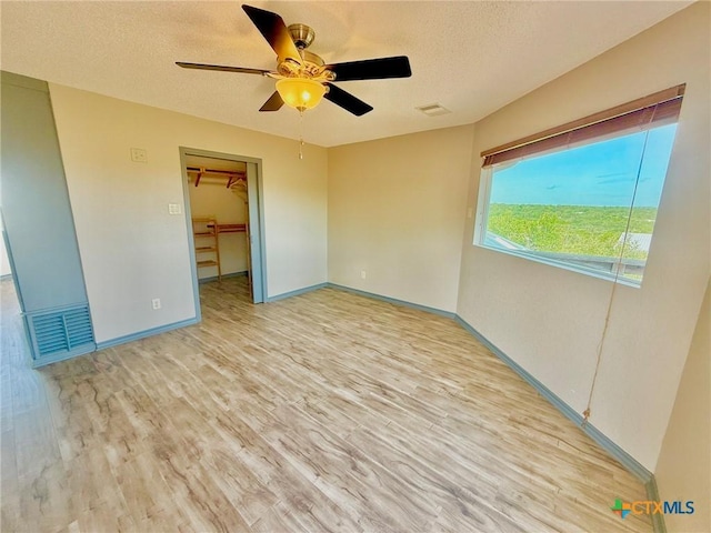 1795 Falconwood Dr, San Marcos, TX 78666 - unfurnished room featuring wood finished floors, a ceiling fan, and a textured ceiling