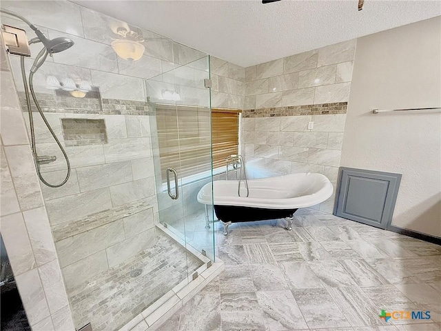 1795 Falconwood Dr, San Marcos, TX 78666 - full bath with a freestanding tub, a shower stall, a textured ceiling, and tile walls