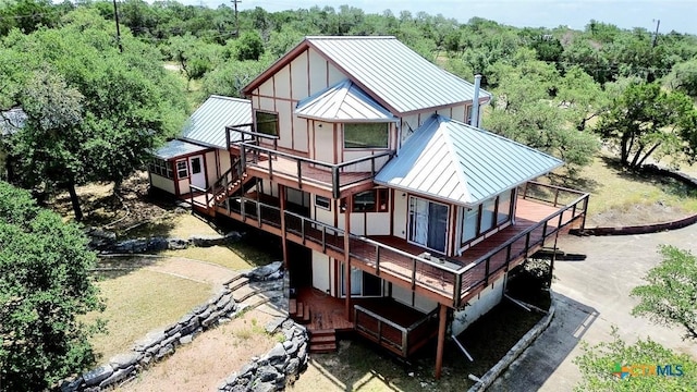 1795 Falconwood Dr, San Marcos, TX 78666 - back of property with a standing seam roof, a metal roof, a deck, board and batten siding, and a view of trees