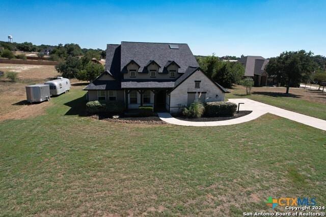 view of front of property with a front lawn, cooling unit, and concrete driveway