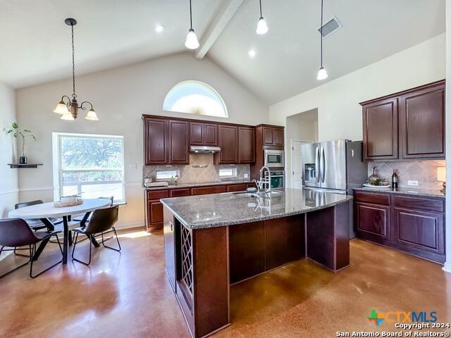 kitchen featuring high vaulted ceiling, a sink, under cabinet range hood, stainless steel appliances, and concrete floors