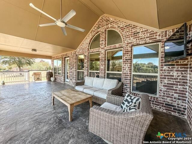 view of patio with an outdoor living space, a ceiling fan, and fence