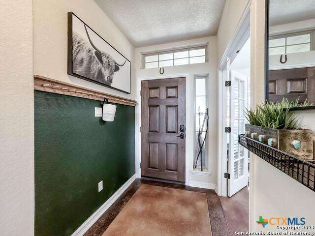 foyer entrance with wood finished floors and baseboards