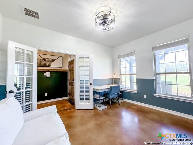 home office featuring visible vents, finished concrete flooring, and baseboards