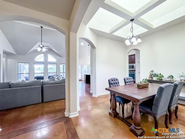 dining area featuring a ceiling fan, coffered ceiling, arched walkways, concrete floors, and baseboards