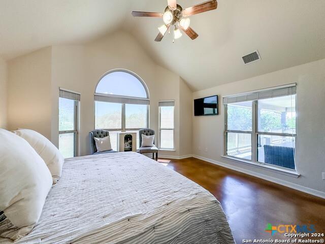 bedroom with visible vents, multiple windows, high vaulted ceiling, and baseboards