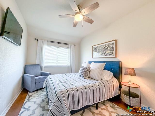 bedroom featuring baseboards, lofted ceiling, and a ceiling fan