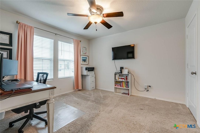 carpeted office space featuring ceiling fan