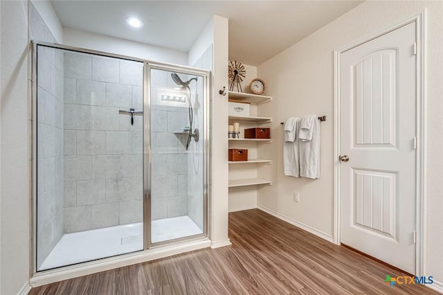 bathroom with hardwood / wood-style flooring and a shower with door