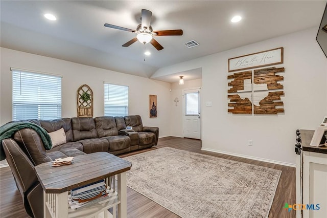 living room with dark wood-type flooring, ceiling fan, and vaulted ceiling