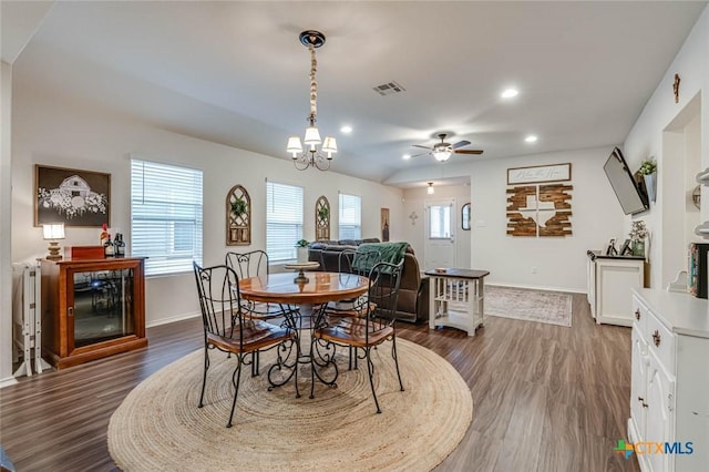 dining room featuring a healthy amount of sunlight, ceiling fan with notable chandelier, and dark hardwood / wood-style flooring