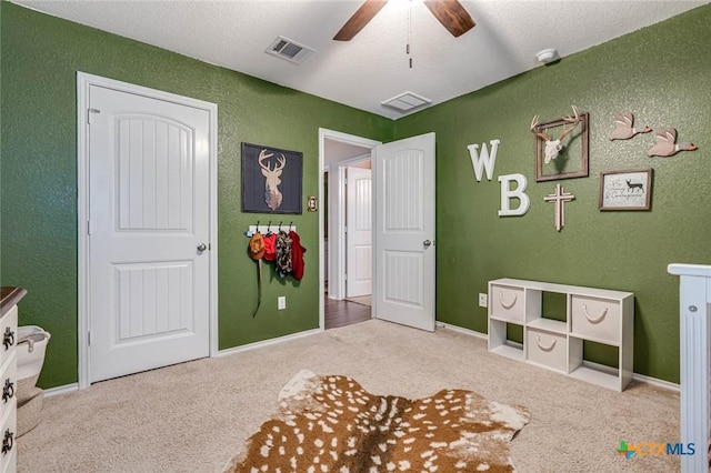 interior space featuring ceiling fan and a textured ceiling