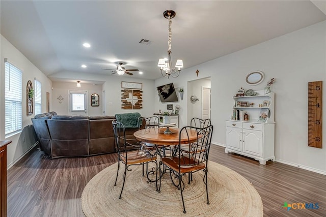 dining room with dark wood-type flooring and ceiling fan with notable chandelier