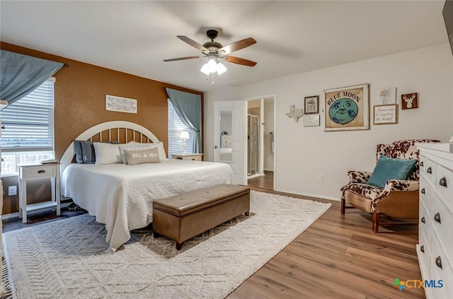 bedroom with ceiling fan, connected bathroom, and light hardwood / wood-style flooring