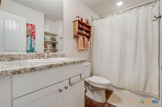 bathroom with wood-type flooring, toilet, and vanity