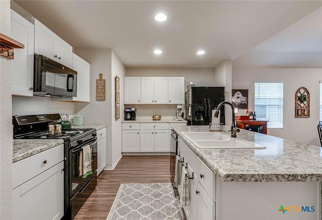 kitchen with sink, white cabinets, a kitchen island with sink, black appliances, and dark wood-type flooring