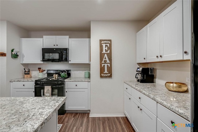 kitchen with dark hardwood / wood-style flooring, light stone counters, black appliances, and white cabinets