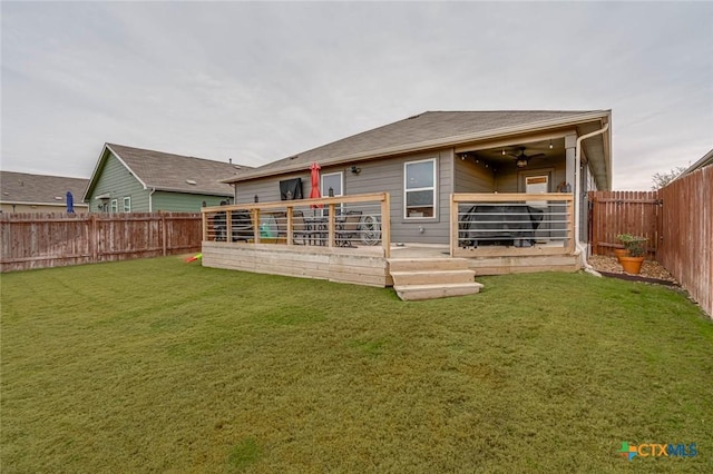 back of house featuring ceiling fan, a yard, and a deck