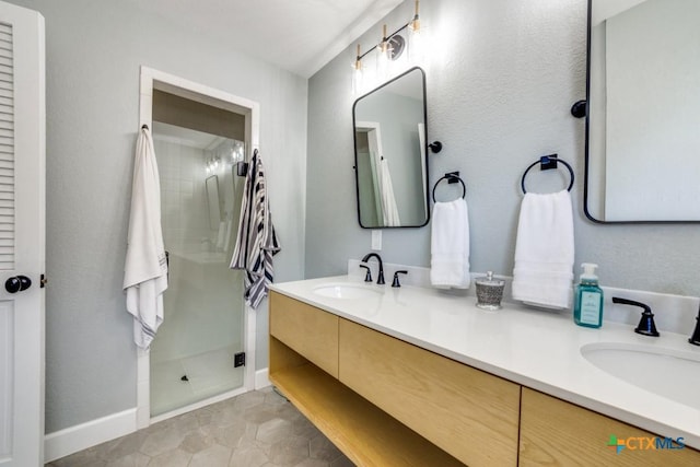 bathroom featuring a sink, double vanity, a shower stall, and tile patterned flooring