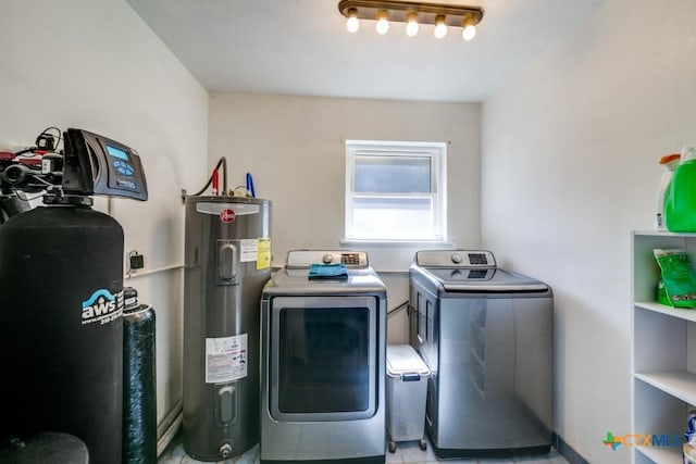 washroom featuring laundry area, electric water heater, and washing machine and clothes dryer