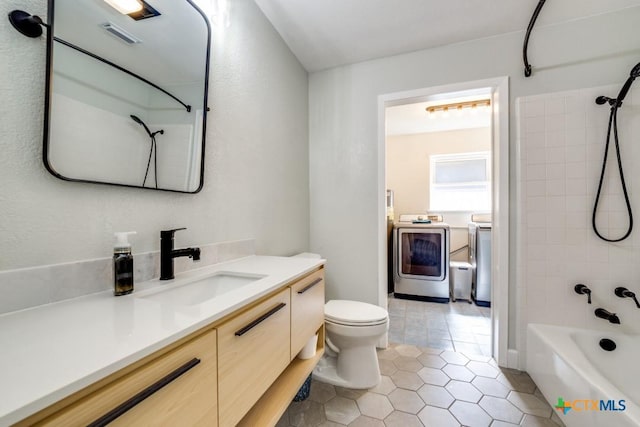 bathroom featuring vanity, bathtub / shower combination, tile patterned floors, toilet, and washer and clothes dryer