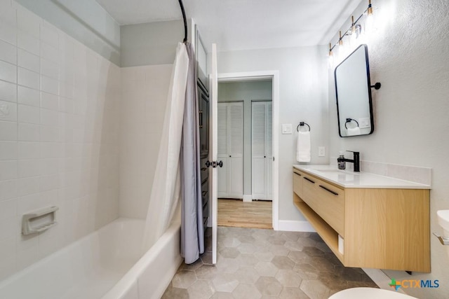 full bathroom with toilet, vanity, baseboards, and shower / bath combo