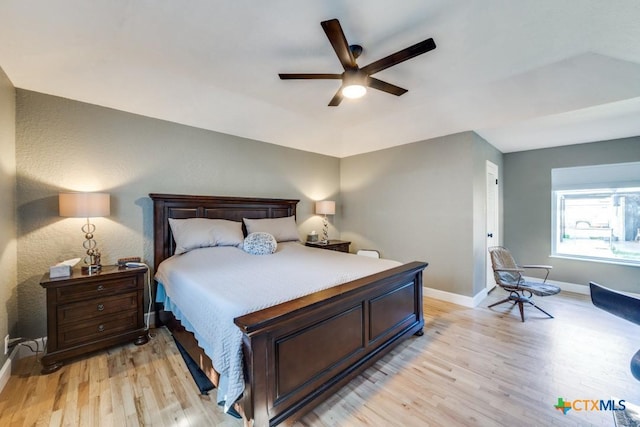 bedroom with baseboards, a ceiling fan, and light wood finished floors