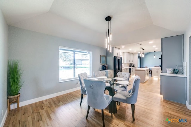 dining area featuring recessed lighting, light wood-type flooring, baseboards, and vaulted ceiling