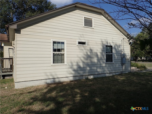 view of side of home with a yard