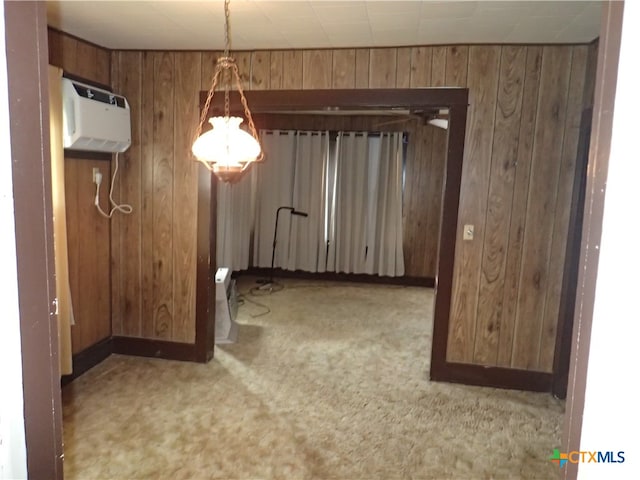 unfurnished dining area with a wall unit AC, light colored carpet, and wooden walls