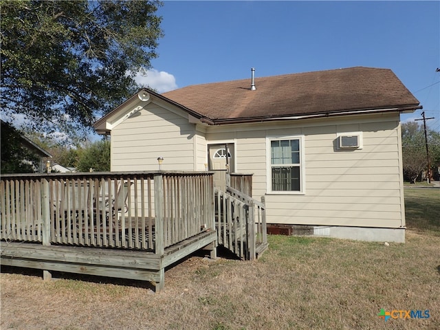 rear view of house featuring a lawn and a deck