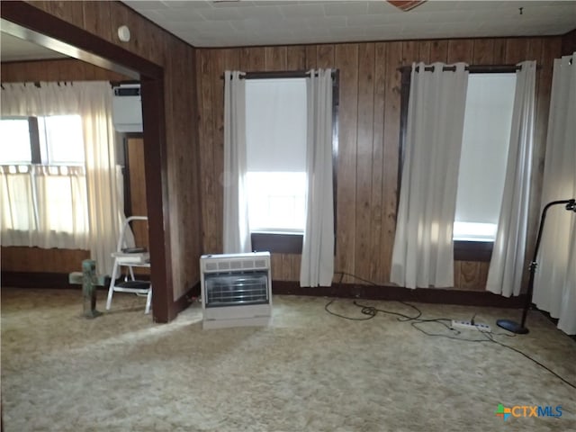 unfurnished bedroom with carpet flooring, heating unit, and multiple windows