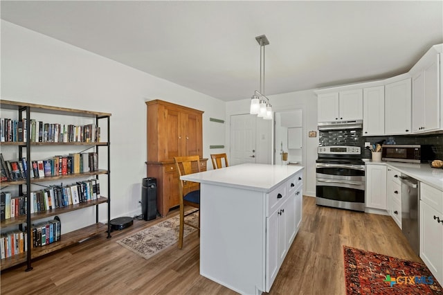 kitchen with stainless steel appliances, white cabinetry, light wood-type flooring, and a kitchen island